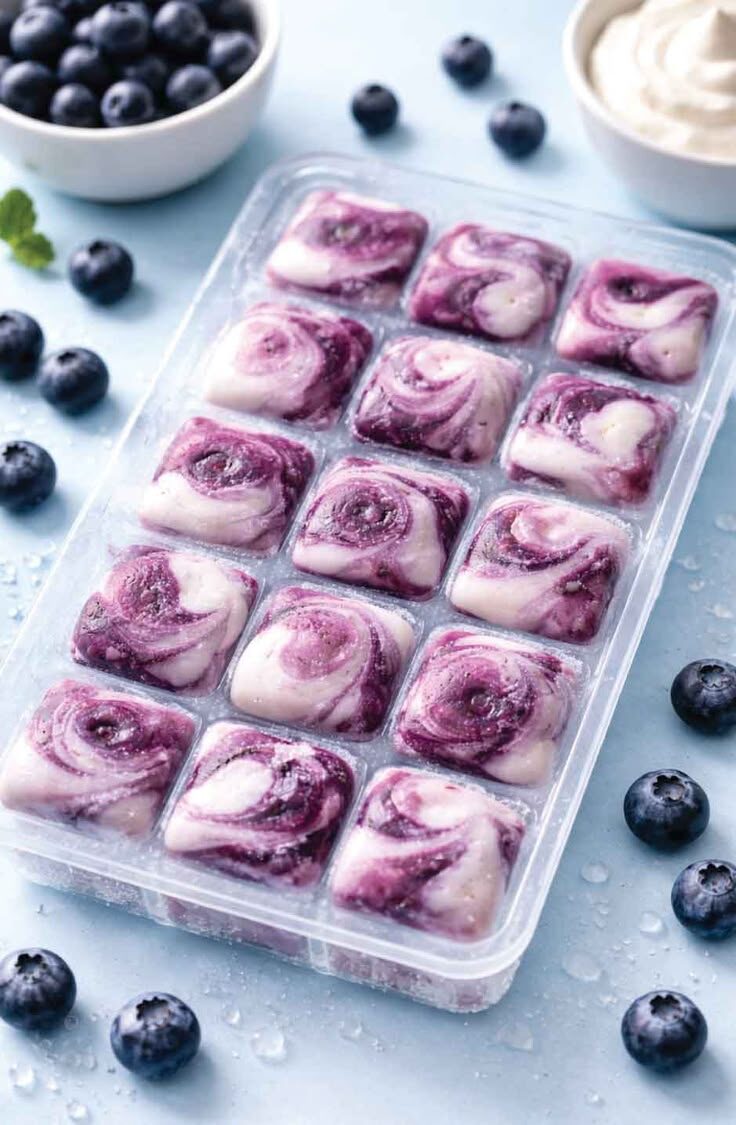Cubos congelados de yogur con arándanos en bandeja de silicona
