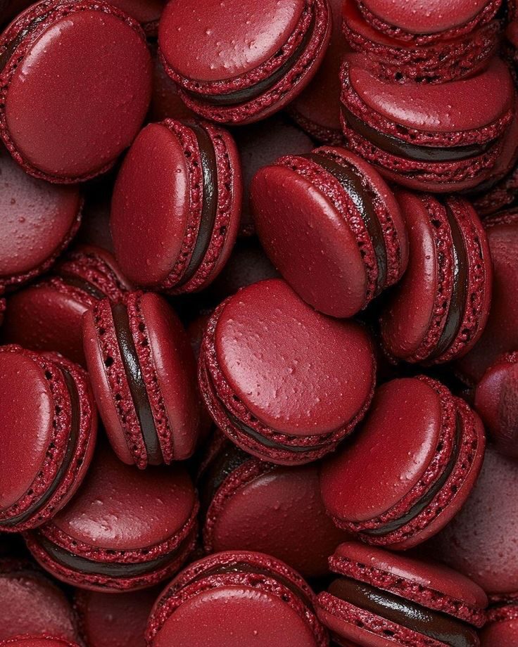 Macarons rojo vino con relleno oscuro, recién preparados